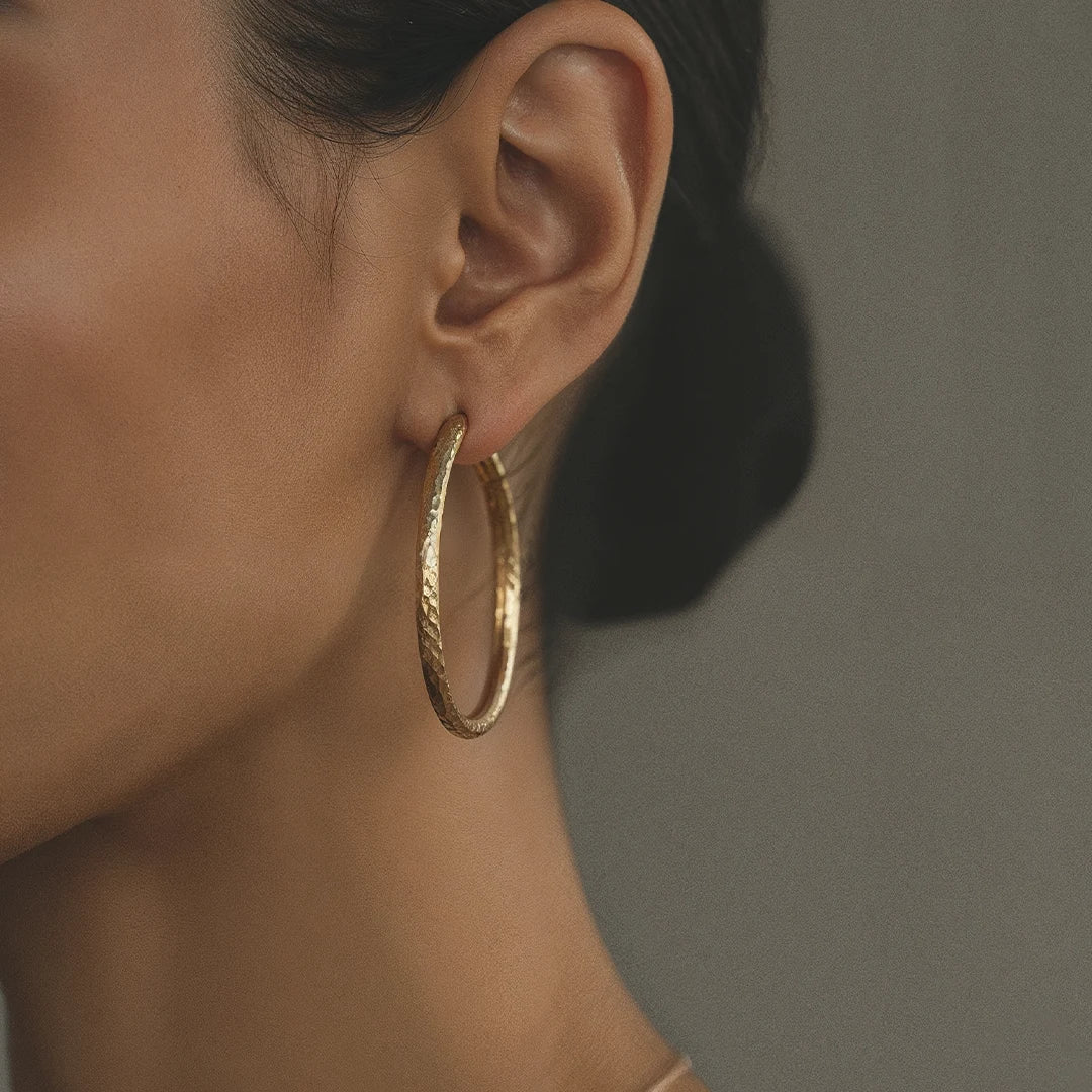 A textured Roy gold hoop against the skin